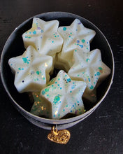 Load image into Gallery viewer, phot of a jar of wax melts, the melts are white in colour and they are covered in blue glitter in a black cardboard tube style packaging
