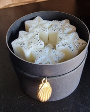 Load image into Gallery viewer, A photo of some wax melts in a cardboard round gift jar, the wax melts are white in colour and covered in glitter
